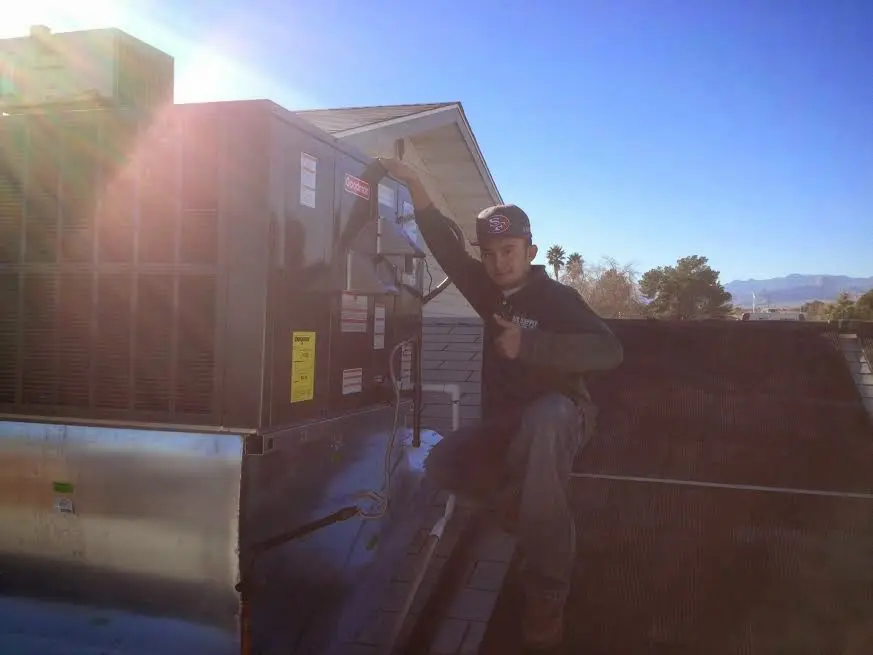 HVAC technician performing Heat Pump Repair on a rooftop unit in Millbrook